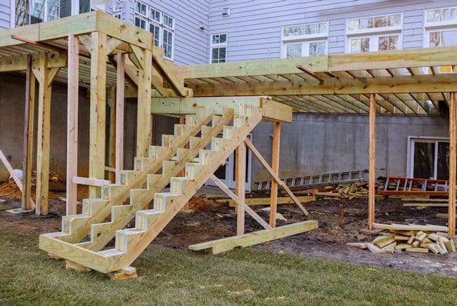 Deck construction includes building a stable foundation that will support the deck boards.